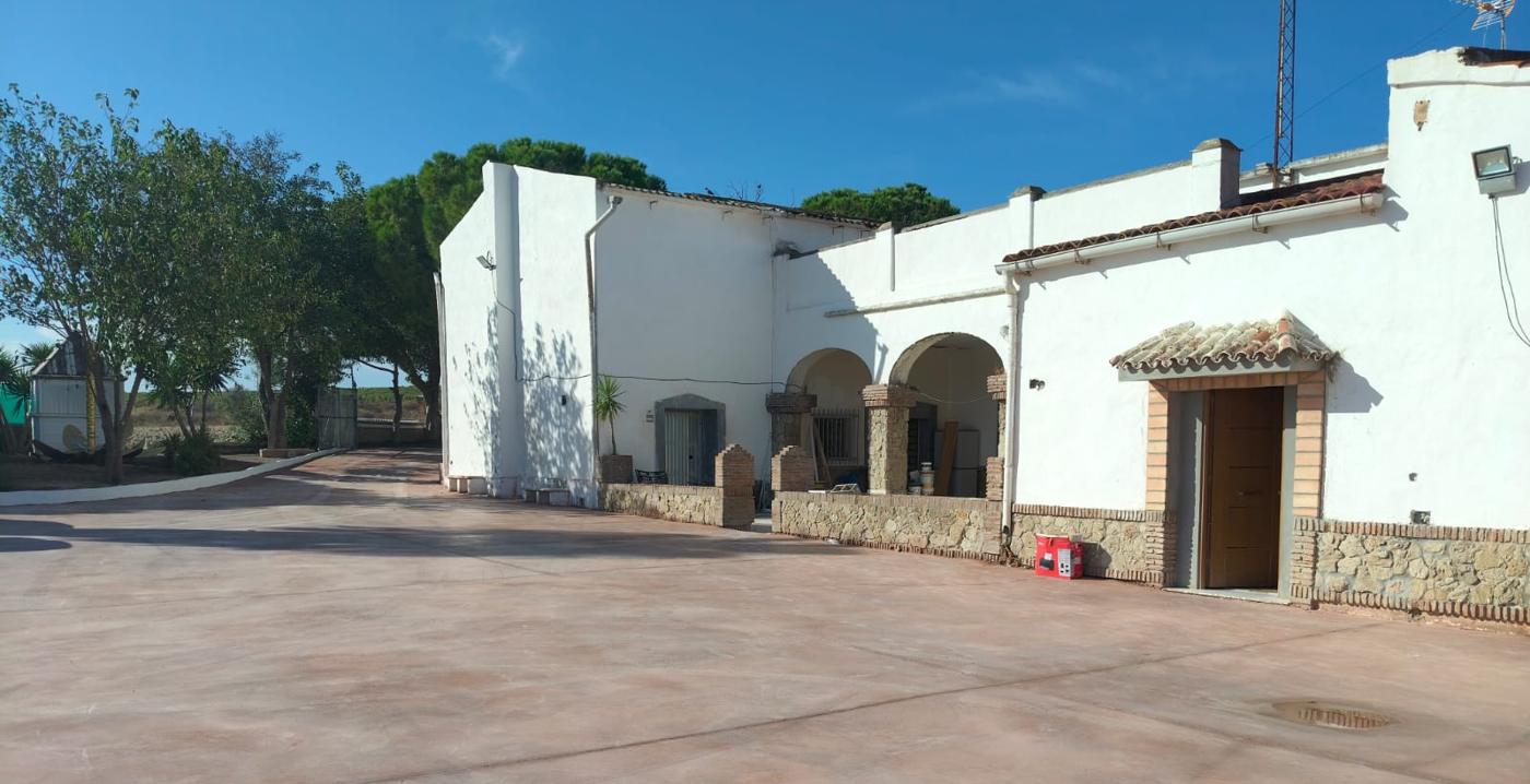 Fachada encalada del cortijo con arcos