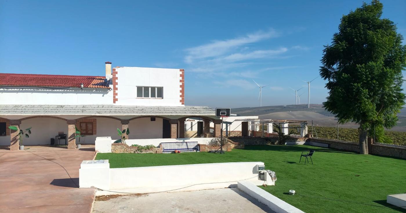 Casa principal, jardín y zona deportiva con el campo al fondo